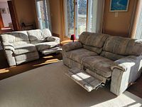 Two matching fabric loveseats with one footrest extended on each