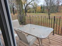 Rectangular glass patio table with metal frame and umbrella hole on deck