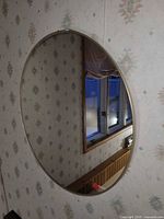 Round wall mirror hanging on patterned wall