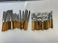 Knives and forks laid out on white background