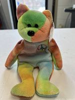 Front view of Ty Peace Bear showing tie-dye colors and embroidered peace symbol