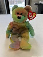 Front view of Ty Peace Bear plush showing tie-dye colors, embroidered peace sign and hang tag