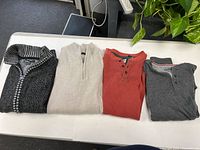 All four folded tops displayed on table