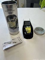 Watch, metal tube, lid and instruction leaflet overview