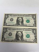 Fronts of two uncut $1 bills