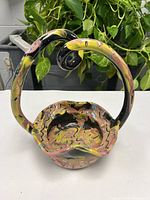 Front view of ceramic bowl showing marbled glaze, wavy rim and twisted handle