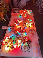 Overview of lit vintage Christmas light strands and bag of spare bulbs
