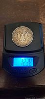 Reverse of coin on scale reading 12.38 g