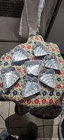 Seven aluminum Christmas tree molds on floral cloth
