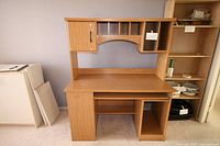 Front view of assembled desk with hutch showing shelving, cabinet, CD rack and pull-out keyboard tray