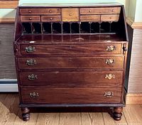 Front view showing fall-front open, interior drawers, pigeonholes, four lower drawers, brass hardware, turned feet
