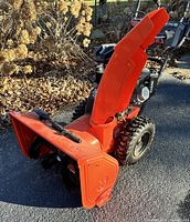 Front left view showing entire snowblower, discharge chute upright