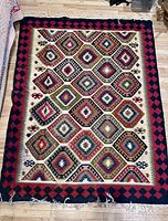 Full view of kilim rug showing pattern, colors, borders and fringes