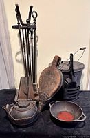 Full lot showing fireplace tool set, bellows, teapot, dutch oven, ash bucket with shovel