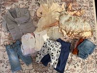 Overview of blazer, dresses, pants, leggings, onesies and folded items