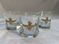 Front view of three glasses showing gold bird design and hexagonal bases