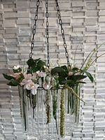 Close view of chandelier showing glass tubes, brass ring, flowers