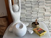 All items together: stone statue, bronze bowl with striker, white diffuser with adapter, sealed oracle card deck