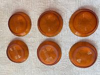 Six amber glass bowls upside down showing bases and pattern