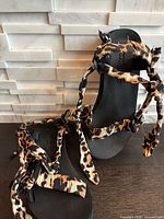 Top view of both sandals showing leopard print straps and black footbeds