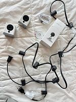 Group shot of both Wyze cameras, USB cable, string lights, box and sticker