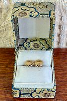 Earrings displayed in open fabric-covered jewellery box