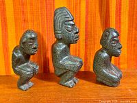 front view of the three greenstone figurines against textile backdrop