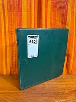 Closed green binder with MaxSold lot sticker