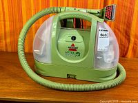 Full view of BISSELL Little Green cleaner showing hose and body