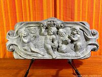 Front view of cast concrete wall plaque showing full relief scene