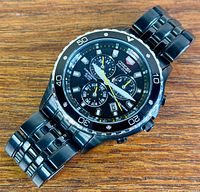 Front view of Citizen Eco-Drive black chronograph watch on wood surface