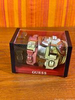 Clear Guess display case holding watches and straps