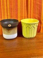 Both planters side by side on wood surface against striped fabric backdrop