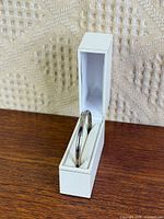 bangle bracelet standing upright inside white hinged box