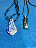 Both pendant necklaces laid flat to show full length and designs