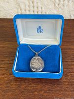 Birks sterling locket on chain in open blue box, interior showing logo