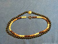 Both faux pearl necklaces coiled to show full strands and clasps