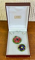 Pendant and brooch in jeweller’s box, showing painted fronts