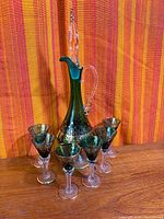 full decanter with stopper surrounded by five glasses