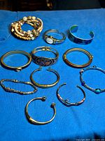 All bracelets laid out on blue surface, showing variety