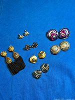 All seven pairs of earrings arranged on blue background