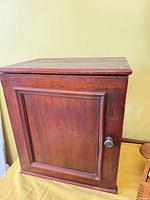 Front view of wooden cabinet showing recessed panel door and knob