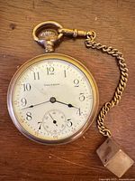 Front view of Waltham pocket watch with attached chain and key