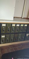 Front view showing twelve olive green drawers with label holders and handles