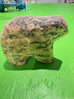 Side view of speckled stone animal figurine