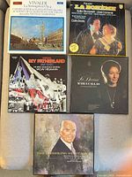 Five record covers arranged on surface