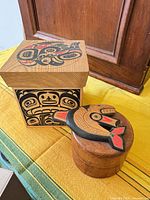 Square carved box and round lidded bowl on display