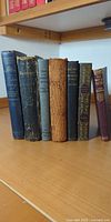 Seven poetry books standing showing spines