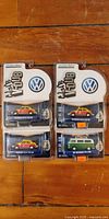 Front view showing four GreenLight Club V-Dub blister-pack cars: three Beetle Taxi Cabs and one Type 2 Bus