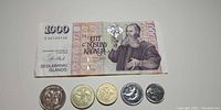 Front of 1000 krónur banknote with five Icelandic coins obverse side